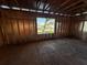 Unfinished room framed with a window to view the neighborhood and plywood flooring at 3627 Lincoln St, Sanford, FL 32771