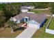 Aerial view of a blue home with a brown roof, a driveway, and landscaping at 417 Rio Grande Ct, Kissimmee, FL 34759