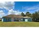 Home's backyard showcasing a patio with outdoor seating and expansive green space at 417 Rio Grande Ct, Kissimmee, FL 34759