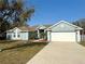 Charming single-story home with a well-manicured lawn, attached two-car garage, and lush landscaping at 417 Rio Grande Ct, Kissimmee, FL 34759