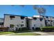 Two-story condo features classic black awnings, clean white paint, and lush landscaping at 4205 S Semoran Blvd # 3, Orlando, FL 32822