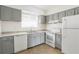 Well-lit kitchen featuring white appliances, gray cabinets, and granite countertops at 4205 S Semoran Blvd # 3, Orlando, FL 32822