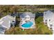 Aerial view of a community pool, surrounded by lounge chairs and landscaped grounds, between condominium buildings at 5258 Tunbridge Wells Ln # 1902, Orlando, FL 32812