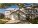 Charming townhome showcasing dual garages, brick accents, and mature trees providing ample shade at 5258 Tunbridge Wells Ln # 1902, Orlando, FL 32812