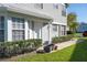 A welcoming front entrance featuring a clean white door, complemented by lush green bushes and decorative planters at 5258 Tunbridge Wells Ln # 1902, Orlando, FL 32812