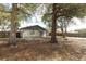 The home's exterior backyard with mature trees and a concrete patio at 558 Tyler Ave, Deltona, FL 32725