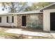 Close-up of home featuring stone facade, black front door, and inviting outdoor seating area at 558 Tyler Ave, Deltona, FL 32725