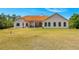 Expansive home exterior showcasing the lush green lawn and mature trees, complete with a covered patio at 6005 Bancroft Blvd, Orlando, FL 32833