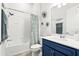 Bright bathroom features a shower with a tub and a blue vanity with a white countertop at 6117 Sandy Springs Ct, St Cloud, FL 34771