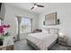 Comfortable bedroom with a ceiling fan, a window with natural light, and a large painting on the wall at 6117 Sandy Springs Ct, St Cloud, FL 34771