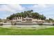 View of the Del Webb Sunbridge community entrance with a tiered water feature surrounded by palm trees at 6117 Sandy Springs Ct, St Cloud, FL 34771