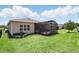 Exterior of house showing the screened lanai with a backyard, luscious green grass, and well-kept landscaping at 6117 Sandy Springs Ct, St Cloud, FL 34771