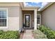 Inviting entryway with a glass-paneled front door, manicured greenery, and a welcoming ambiance at 6117 Sandy Springs Ct, St Cloud, FL 34771