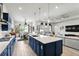 Open kitchen with a large island, modern pendant lighting, and seamless transition to the living area at 6117 Sandy Springs Ct, St Cloud, FL 34771