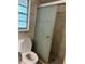 Modern bathroom featuring a shower with a patterned glass sliding door, toilet and tiled walls at 6567 Magee Ct, Orlando, FL 32818
