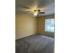 Cozy bedroom featuring neutral walls, carpeted flooring, ceiling fan, and a window with outdoor view at 6567 Magee Ct, Orlando, FL 32818