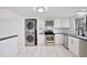 Bright kitchen features modern appliances, white cabinetry and convenient laundry closet at 713 Saint Matthew Cir, Altamonte Springs, FL 32714