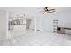 Open-concept living room with white tile, ceiling fan, staircase, and view to the kitchen at 713 Saint Matthew Cir, Altamonte Springs, FL 32714