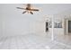 Open-concept living room with white tile, ceiling fan, and view to the kitchen with laundry at 713 Saint Matthew Cir, Altamonte Springs, FL 32714