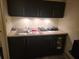 The well-lit kitchenette is equipped with sleek, dark cabinets and modern appliances at 7900 S Orange Blossom Trl # 2052, Orlando, FL 32809