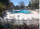 A beautiful swimming pool is surrounded by lounge chairs and a white picket fence at 7900 S Orange Blossom Trl # 2052, Orlando, FL 32809
