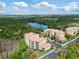 Scenic aerial view of a multi-unit residential community near a lake and lush green landscape at 8763 Worldquest Blvd # 5306, Orlando, FL 32821