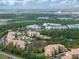 Panoramic aerial shot showing condo community amidst a lush green environment, with a lake and community pool at 8763 Worldquest Blvd # 5306, Orlando, FL 32821