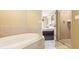 Elegant bathroom featuring a soaking tub and glass-enclosed shower, adjacent to an opening into the bedroom at 8763 Worldquest Blvd # 5306, Orlando, FL 32821