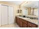 Bathroom featuring a double sink vanity with granite countertop, a large mirror, and tile flooring at 8763 Worldquest Blvd # 5306, Orlando, FL 32821