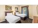 Comfortable bedroom with two beds, a window with curtains, and decorative artwork at 8763 Worldquest Blvd # 5306, Orlando, FL 32821