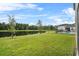 Beautiful backyard with a lush lawn, pond view, and a pool beyond the fence at 889 Terrapin Dr, Debary, FL 32713