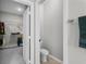 Half bathroom with small toilet and towel rack next to open closet with wire shelving at 889 Terrapin Dr, Debary, FL 32713