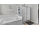 Bright bathroom with tub, frameless glass shower, tiled walls, tile floors, and a large window at 889 Terrapin Dr, Debary, FL 32713