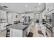 Spacious kitchen featuring stainless steel appliances, a large granite island with seating, and white cabinetry at 889 Terrapin Dr, Debary, FL 32713