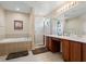 Elegant bathroom boasts double sinks, a glass-enclosed shower, and a relaxing soaking tub at 901 Dorset Pl, Davenport, FL 33896