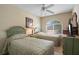 Charming bedroom featuring two twin beds, a ceiling fan and a large, arched window allowing natural light at 901 Dorset Pl, Davenport, FL 33896