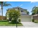Two-story home features lush landscaping, a well-manicured lawn, and a welcoming two-car garage at 901 Dorset Pl, Davenport, FL 33896