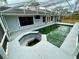 A screened pool with a spa and an outdoor kitchen area for entertainment at 924 Mill Road Ln, Port Orange, FL 32127