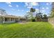 Green backyard with a well maintained lawn and patio with exterior access to the sunroom at 109 Sweetwater Oaks Ln, Daytona Beach, FL 32114