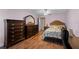 A bedroom featuring dark wood furniture, complementary lamps, and wood-look flooring at 109 Sweetwater Oaks Ln, Daytona Beach, FL 32114