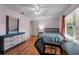 Comfortable bedroom with wood floors, a ceiling fan, a window, and a dresser with mirror at 109 Sweetwater Oaks Ln, Daytona Beach, FL 32114
