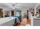 A bright bedroom featuring a mirrored closet, access to a balcony, and a serene blue sofa at 109 Sweetwater Oaks Ln, Daytona Beach, FL 32114