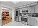 Modern kitchen with stainless steel appliances, gray cabinets, and an open view to the living room at 109 Sweetwater Oaks Ln, Daytona Beach, FL 32114