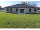 The back of the home showcases a modern white exterior, black roof, and a well-maintained lawn at 13215 Sw 41St Ct, Ocala, FL 34473