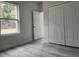 Bedroom with light gray walls, wood-look floors, double closet and a window with natural light at 13215 Sw 41St Ct, Ocala, FL 34473