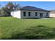 Modern home exterior showing spacious backyard with lush green lawn and contemporary design at 13215 Sw 41St Ct, Ocala, FL 34473