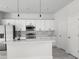 Modern kitchen with white cabinetry, quartz countertops, stainless steel appliances, and a stylish backsplash at 13215 Sw 41St Ct, Ocala, FL 34473