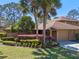 Exterior view of well-maintained townhome featuring colorful landscaping and mature trees at 133 Heron Bay Cir, Lake Mary, FL 32746