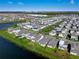 Expansive aerial view of a well-planned community, featuring modern homes and lush landscapes near a tranquil lake at 13589 Mcmillan Dr, Orlando, FL 32827
