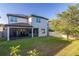 Backyard view showcasing a screened-in patio and a spacious lawn with mature trees at 14602 Winter Stay Dr, Winter Garden, FL 34787